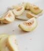 Close-up of sliced melon pieces on a white surface, showcasing their freshness and vibrant color.