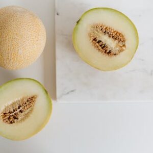 Fresh cantaloupe slices showcasing seeds on a marble background, highlighting healthy nutrition.