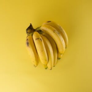 A vibrant bunch of ripe bananas on a matching yellow background, evoking freshness.